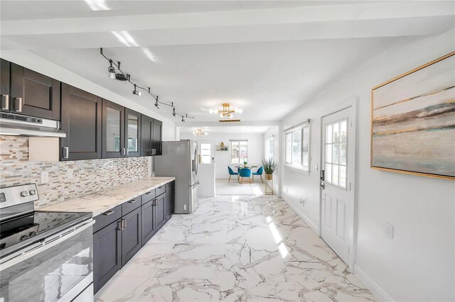 kitchen featuring range hood, decorative backsplash, an inviting chandelier, appliances with stainless steel finishes, and light stone countertops