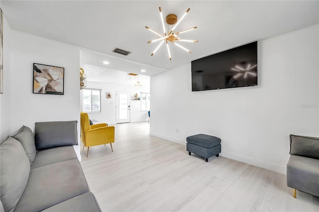 living room featuring light hardwood / wood-style flooring and a chandelier