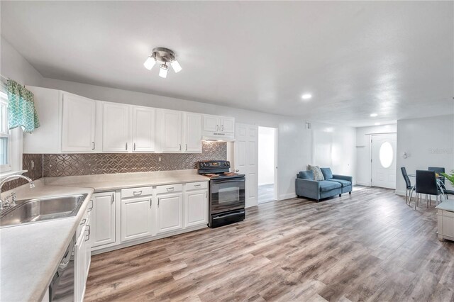 kitchen with light wood-type flooring, black range with electric stovetop, sink, white cabinetry, and stainless steel dishwasher