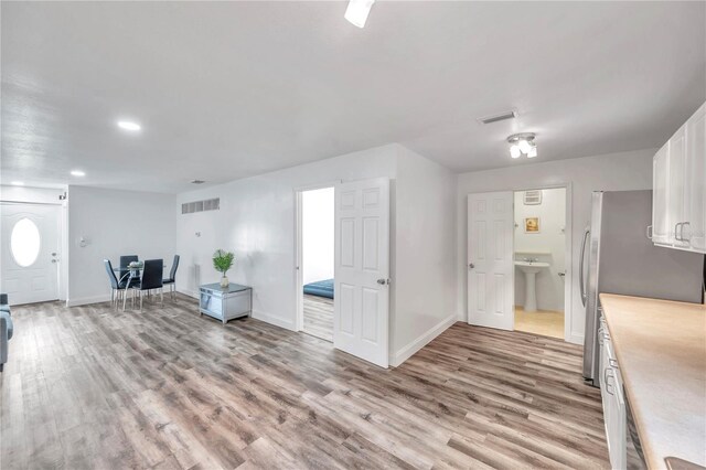 kitchen featuring light wood-type flooring, sink, and white cabinets