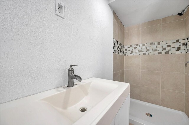 bathroom with vanity and tiled shower