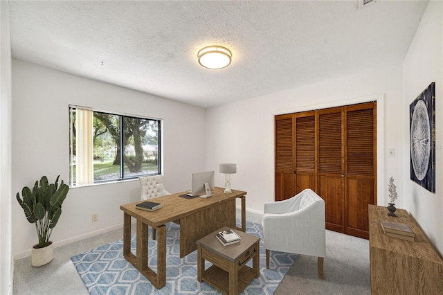 home office featuring light colored carpet and a textured ceiling