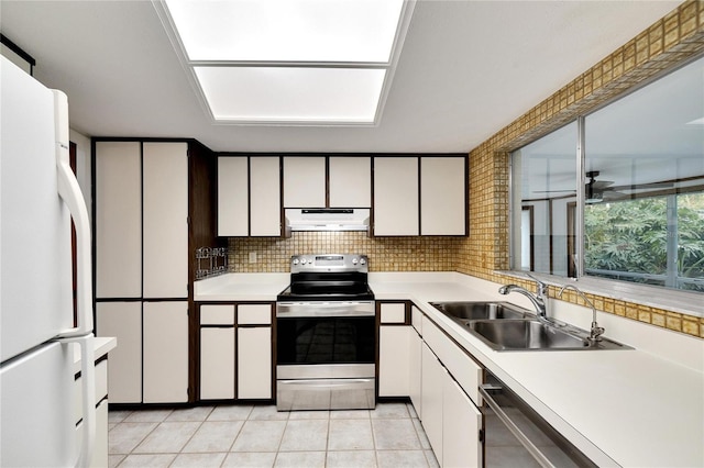 kitchen featuring light tile patterned flooring, tasteful backsplash, sink, white cabinets, and stainless steel appliances