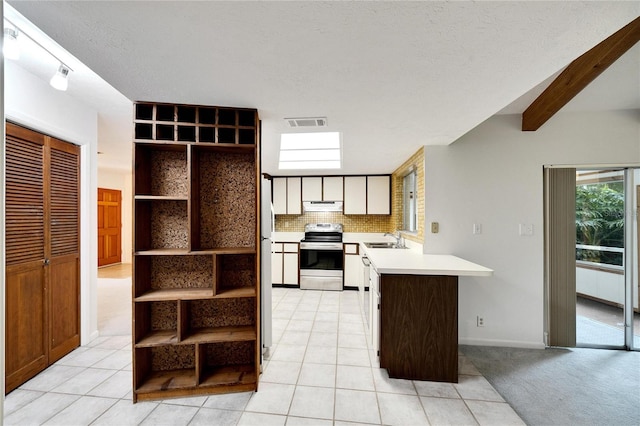 kitchen featuring light tile patterned floors, kitchen peninsula, sink, and electric range