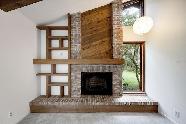 unfurnished living room featuring carpet flooring, vaulted ceiling, and a fireplace