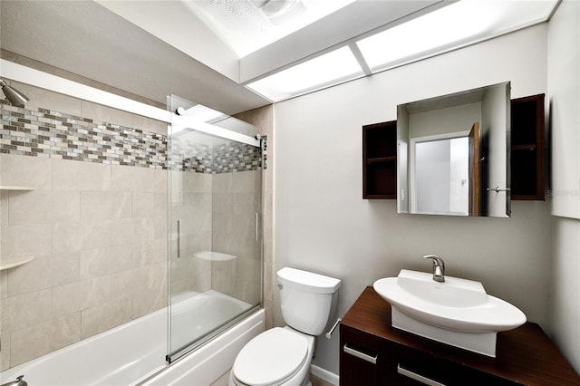 full bathroom with bath / shower combo with glass door, vanity, and toilet