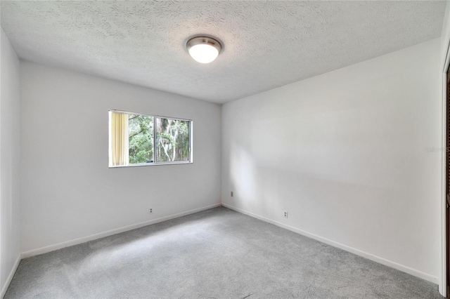 carpeted spare room with a textured ceiling