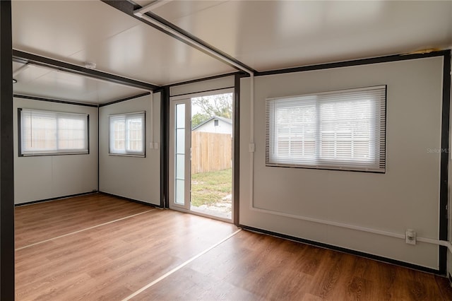 doorway to outside with hardwood / wood-style floors and beamed ceiling