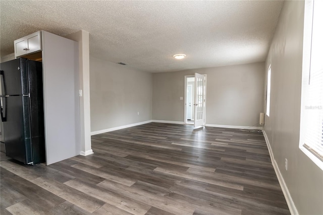 empty room featuring a textured ceiling and dark hardwood / wood-style floors