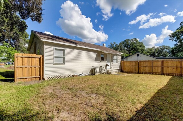 back of house featuring a lawn