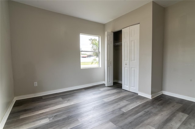 unfurnished bedroom with hardwood / wood-style floors and a closet