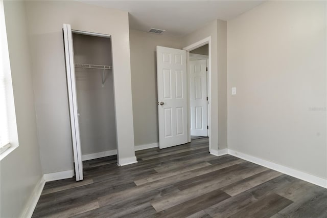 unfurnished bedroom featuring dark hardwood / wood-style floors and a closet