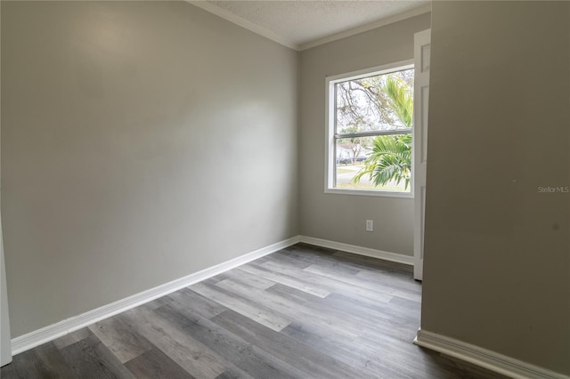 empty room with hardwood / wood-style flooring, ornamental molding, and a textured ceiling