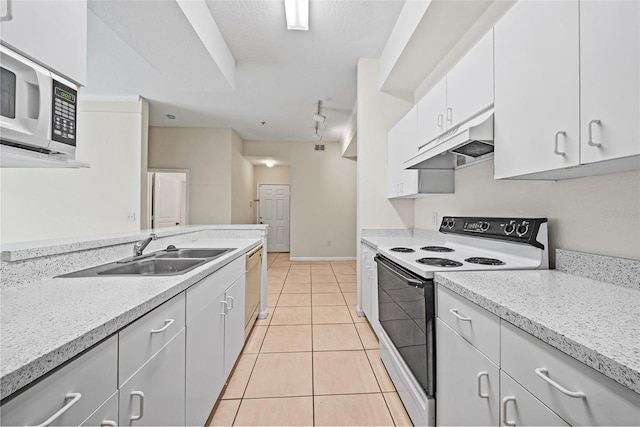 kitchen with light stone counters, sink, white cabinets, electric stove, and light tile patterned floors