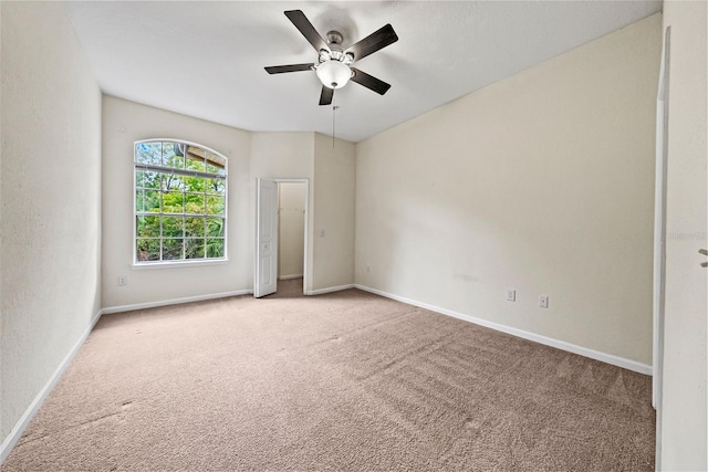 carpeted spare room featuring ceiling fan