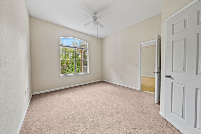 carpeted empty room featuring ceiling fan