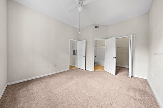 unfurnished bedroom with ceiling fan, light colored carpet, a closet, and ensuite bath