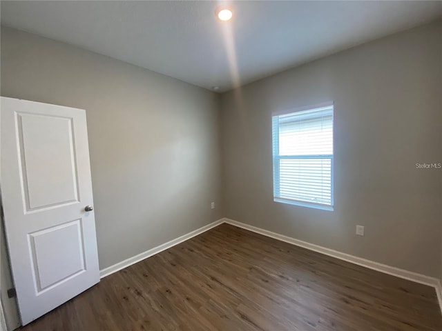 unfurnished room featuring dark wood-type flooring