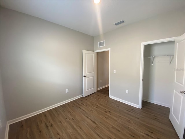 unfurnished bedroom featuring a closet and dark hardwood / wood-style flooring