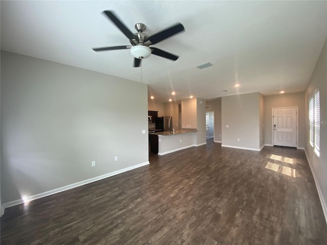 unfurnished living room featuring dark hardwood / wood-style flooring and ceiling fan