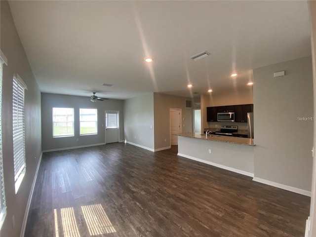 unfurnished living room featuring ceiling fan, dark wood-type flooring, and sink