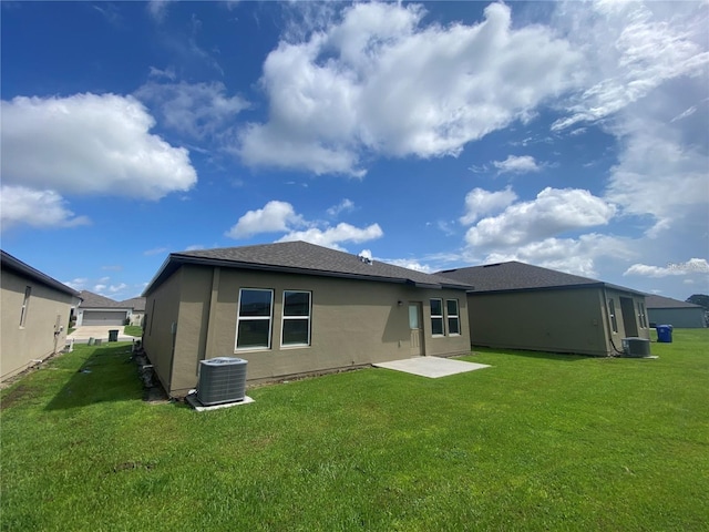 back of house with a yard and central AC