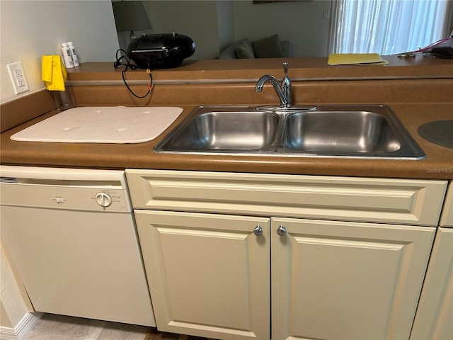 kitchen with dishwasher, cream cabinetry, and sink