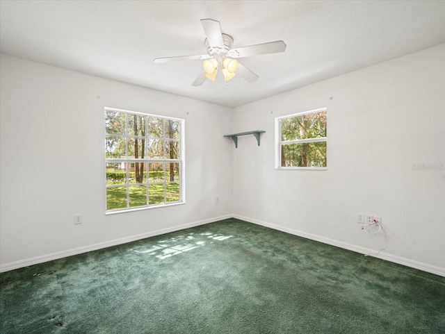 carpeted spare room featuring ceiling fan and a wealth of natural light