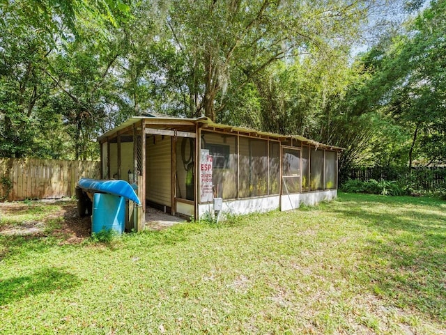 view of outbuilding featuring a sunroom and a yard