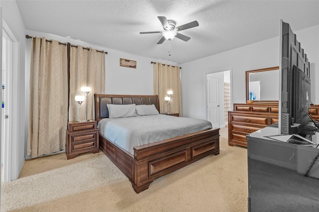 bedroom with ceiling fan, a textured ceiling, ensuite bath, and carpet