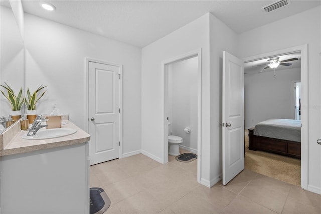 bathroom with tile patterned flooring, ceiling fan, vanity, and toilet