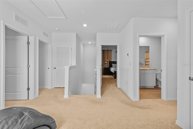 bedroom with light carpet and connected bathroom