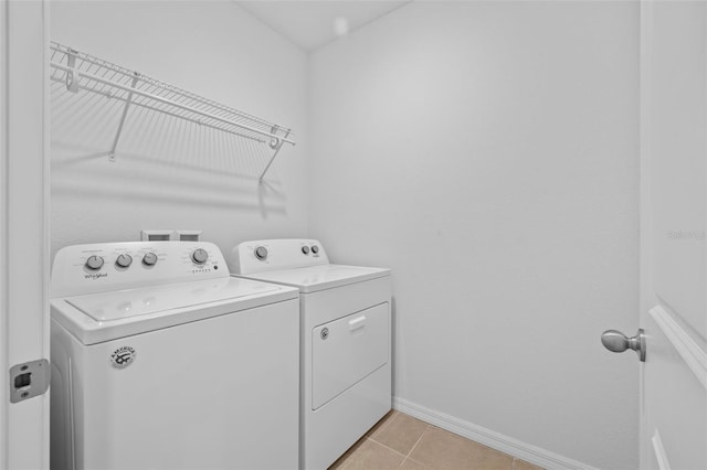 washroom featuring washing machine and dryer and light tile patterned floors