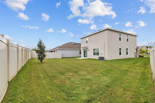 back of house featuring central AC and a lawn