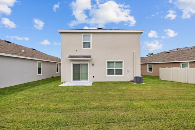 back of property with a yard and central air condition unit