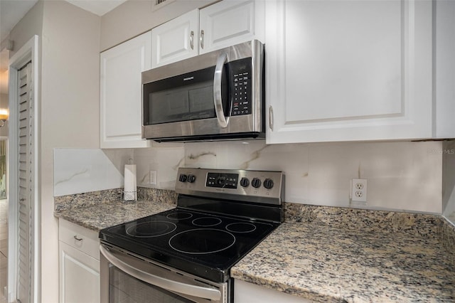 kitchen featuring light stone countertops, appliances with stainless steel finishes, and white cabinetry