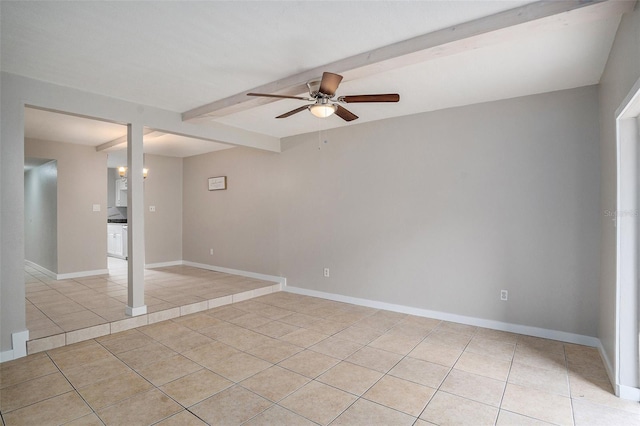 tiled empty room featuring ceiling fan and beamed ceiling