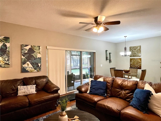 living room featuring wood-type flooring, a textured ceiling, and ceiling fan with notable chandelier