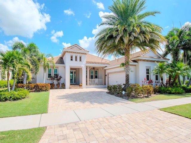 717 Manns Harbor Dr, Apollo Beach, FL 33572 - mediterranean / spanish home featuring stucco siding, a tile roof, decorative driveway, a front yard, and a garage