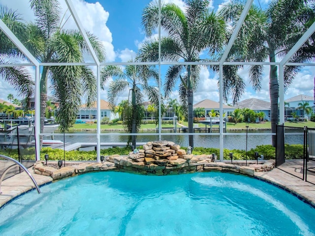 view of pool with glass enclosure and a water view