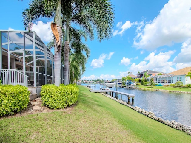 exterior space featuring a water view, a lawn, and a lanai