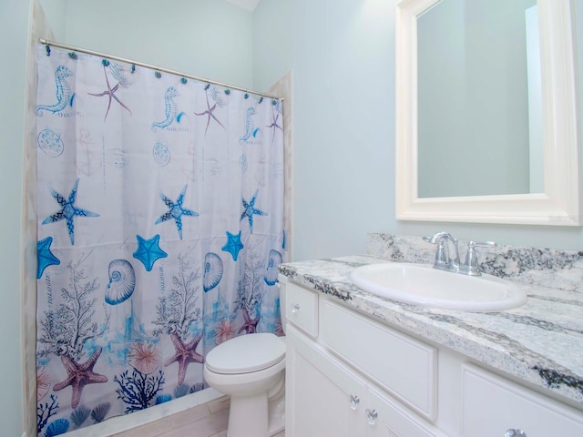 bathroom with walk in shower, vanity, tile patterned flooring, and toilet