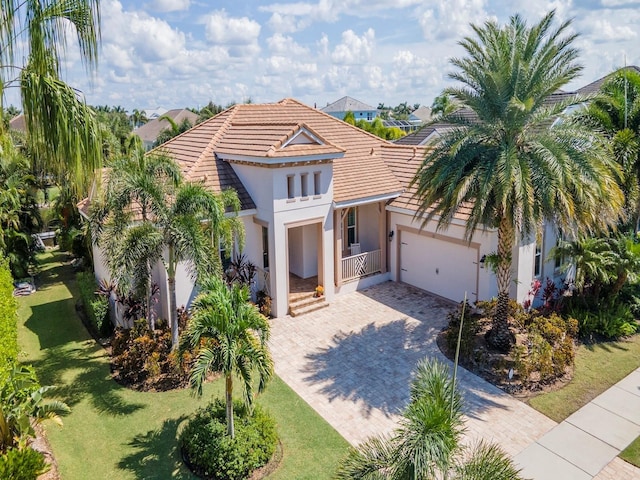717 Manns Harbor Dr, Apollo Beach, FL 33572 - mediterranean / spanish-style house with a garage, driveway, stucco siding, a tile roof, and a front yard