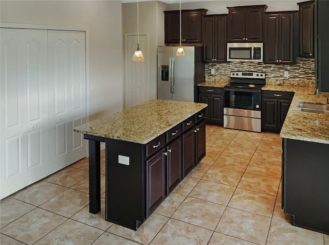 kitchen featuring decorative backsplash, a center island, appliances with stainless steel finishes, and dark brown cabinetry