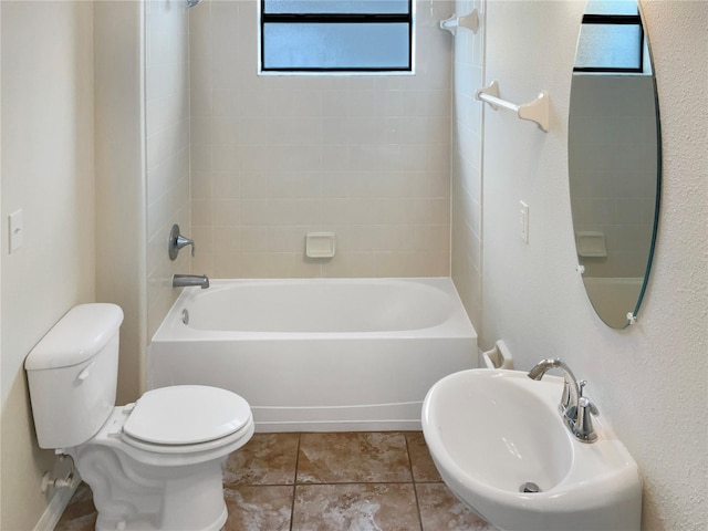 full bathroom featuring tiled shower / bath combo, toilet, sink, and tile patterned floors