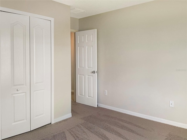 unfurnished bedroom with carpet flooring and a closet