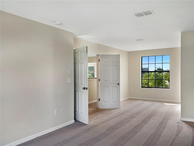 unfurnished room featuring light carpet