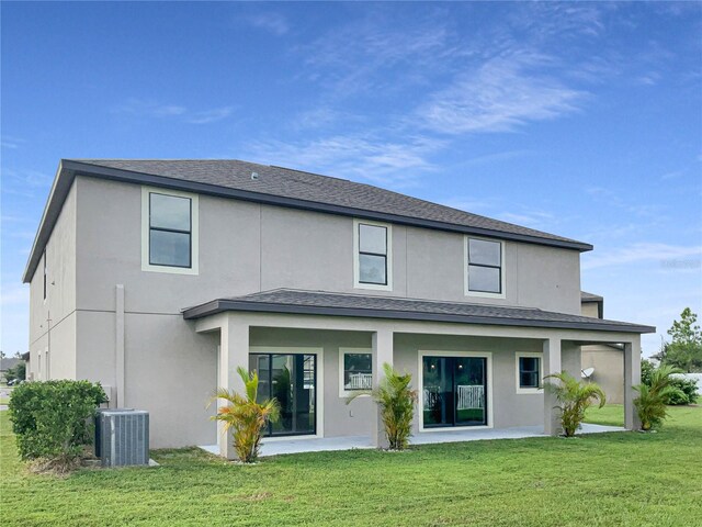 back of house with a lawn, a patio, and central AC