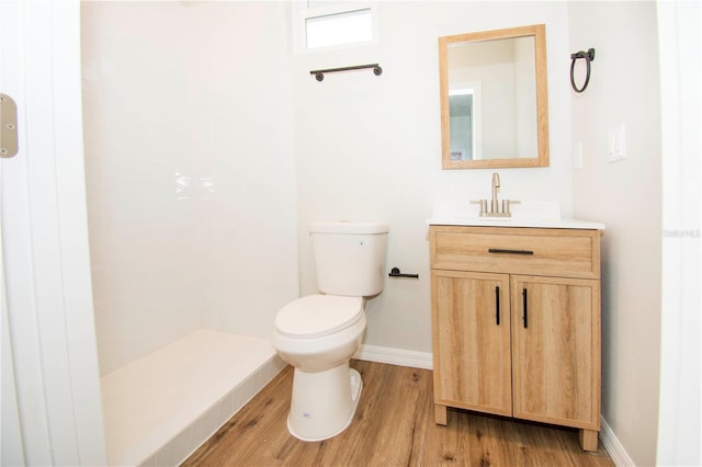 bathroom featuring vanity, toilet, wood-type flooring, and walk in shower