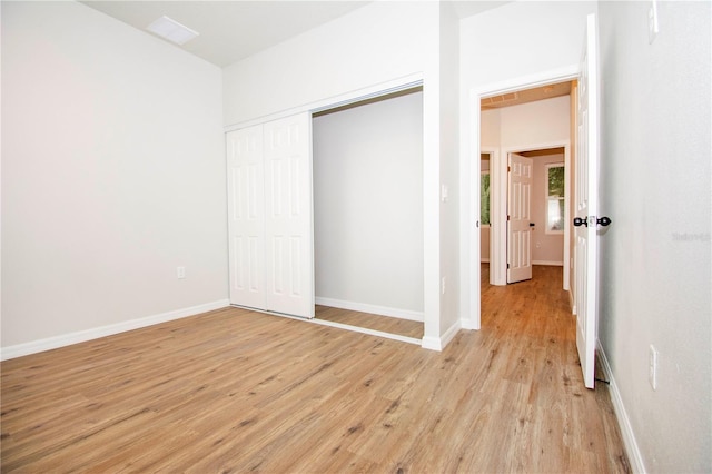 unfurnished bedroom with a closet and light hardwood / wood-style floors